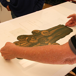 The copper plate is placed on top of the template on the press bed.