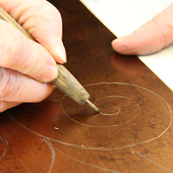 The design is then drawn (in reverse) with an etching-needle with slight pressure. During the drawing, the thin protective hard ground is removed and the copper surface is exposed in these lines.