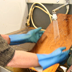 Both sides of the copper plate are rinsed under cold, running water.