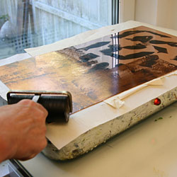 The hard ground is spread over the plate as evenly as possible using a roller.