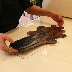 The copper plate is placed on top of the template on the press bed.