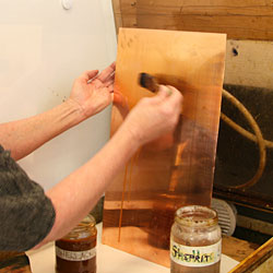 The opposite side of the copper plate is painted with shellac in order to protect it from being etched.