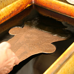 The plate is immersed in the third etching bath.