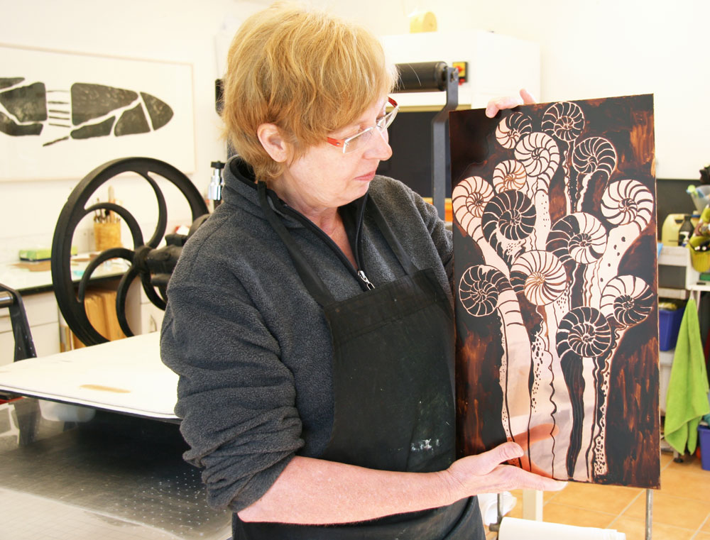 Catharina holds up the pre-painted copper plate which is now ready for the second etching bath.