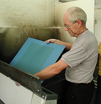 Mr. Jansson in the process of developing of an aluminium sheet (the background of "The Wheel").