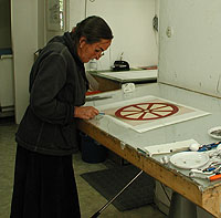 Maria Hillfon is making a final adjustment to the plastic sheet original before the picture is transferred to the aluminium sheet by UV-light.