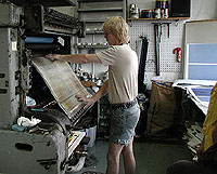 The aluminium sheet is mounted in the printing press. Now the third stage of printing can begin.