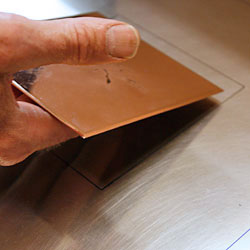 The copper plate is placed at the marking so that the print ends up correctly on the paper.