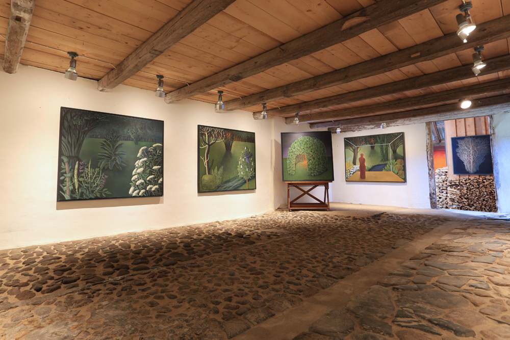Målningar i utställningsrum med kullersten.