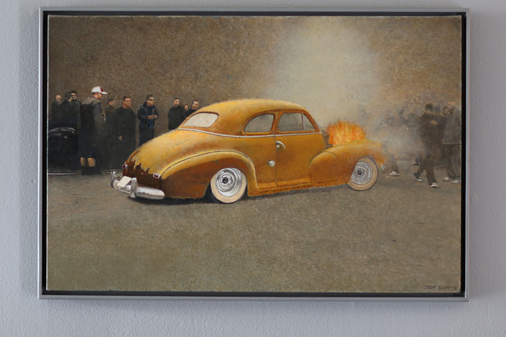 John E Franzéns målning Besökaren 2004-2012, en bil som brinner och ett gäng som tittar på.